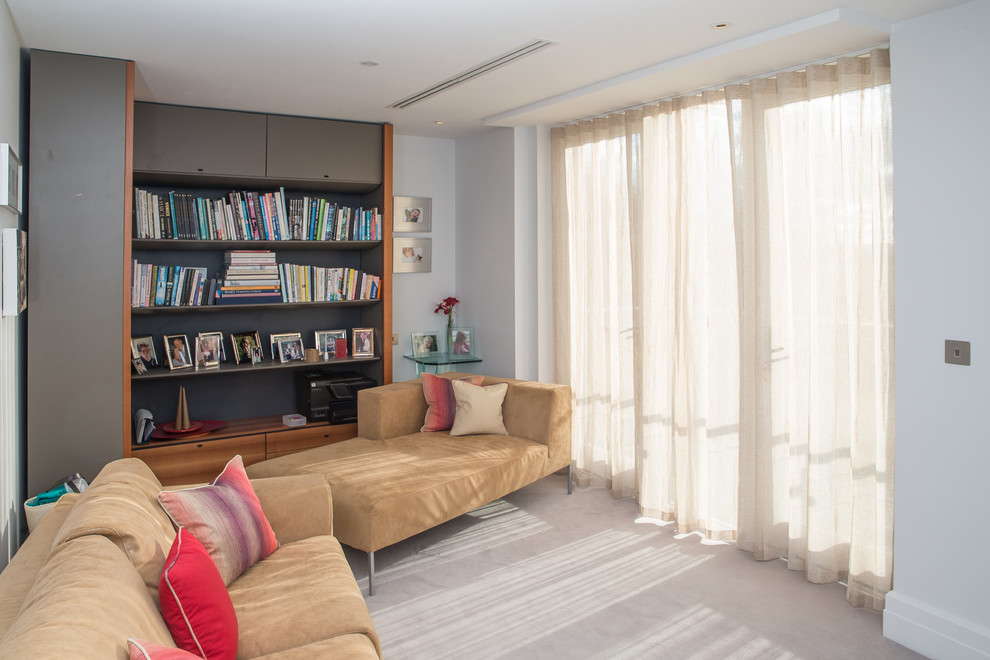 Imagen de sala de estar con biblioteca cerrada contemporánea pequeña con paredes grises, moqueta y suelo gris