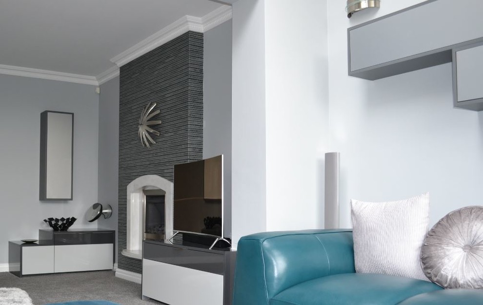 Immagine di un piccolo soggiorno contemporaneo chiuso con sala della musica, pareti grigie, moquette, camino classico e parete attrezzata