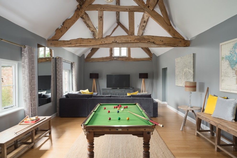Large rural enclosed games room in Cheshire with grey walls, a wall mounted tv and beige floors.