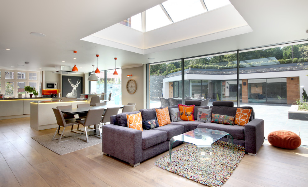 Offenes Modernes Wohnzimmer mit beiger Wandfarbe, hellem Holzboden und beigem Boden in Surrey