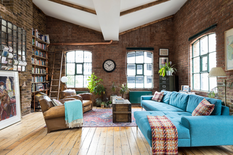 Inspiration for a large urban living room in London with red walls, medium hardwood flooring and brown floors.