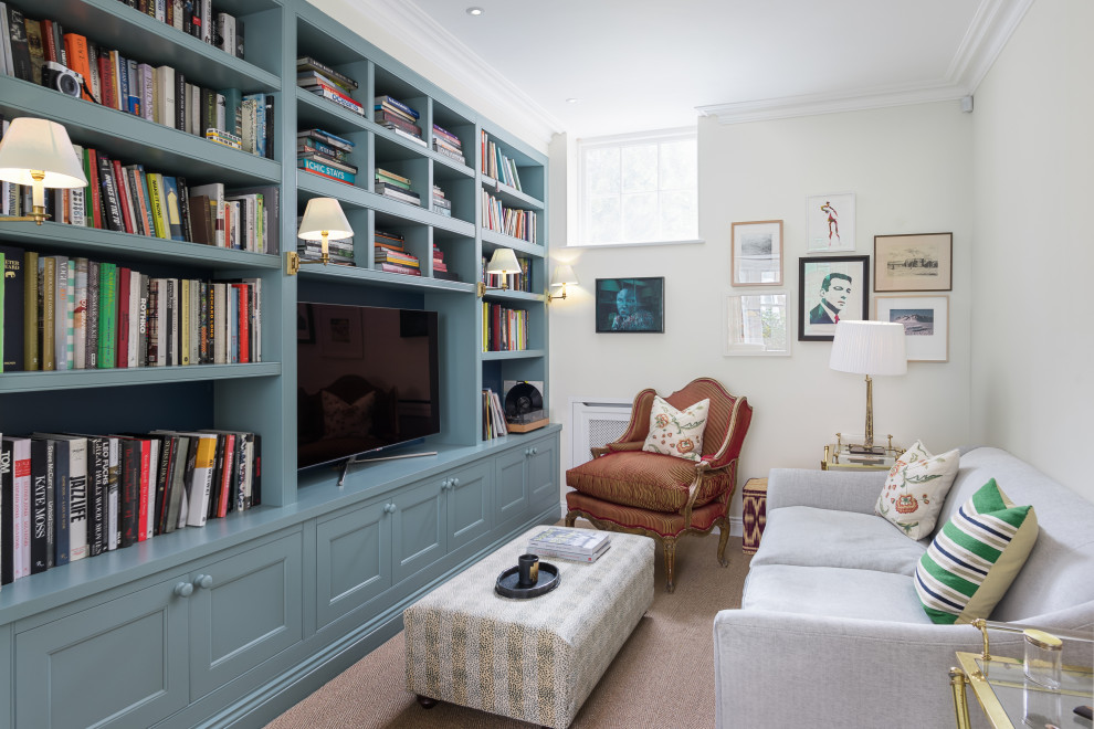 Cette photo montre une salle de séjour chic avec une bibliothèque ou un coin lecture, un mur blanc, moquette, aucune cheminée, un téléviseur encastré et un sol marron.