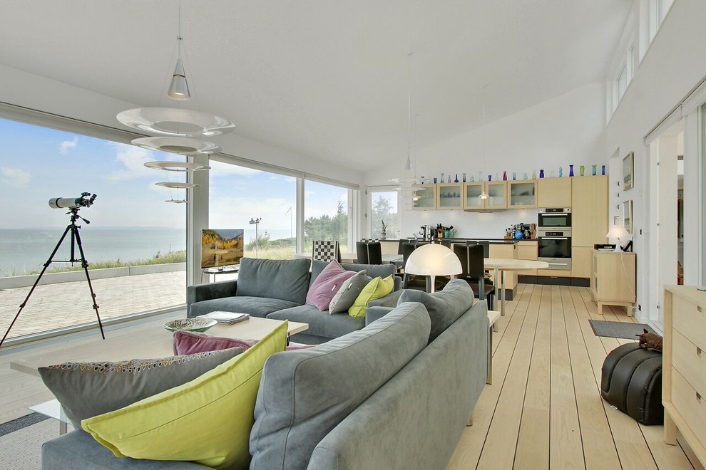 Immagine di un soggiorno contemporaneo aperto con pareti bianche, parquet chiaro, TV autoportante e pavimento beige