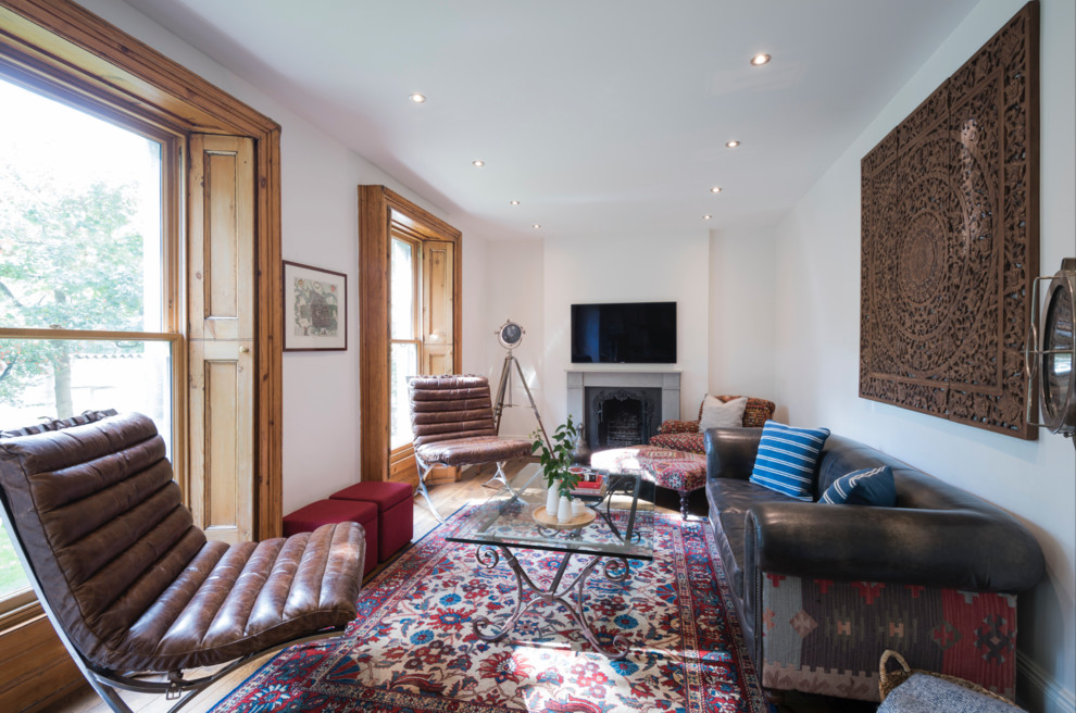 Immagine di un soggiorno tradizionale con pareti bianche, camino classico e TV a parete