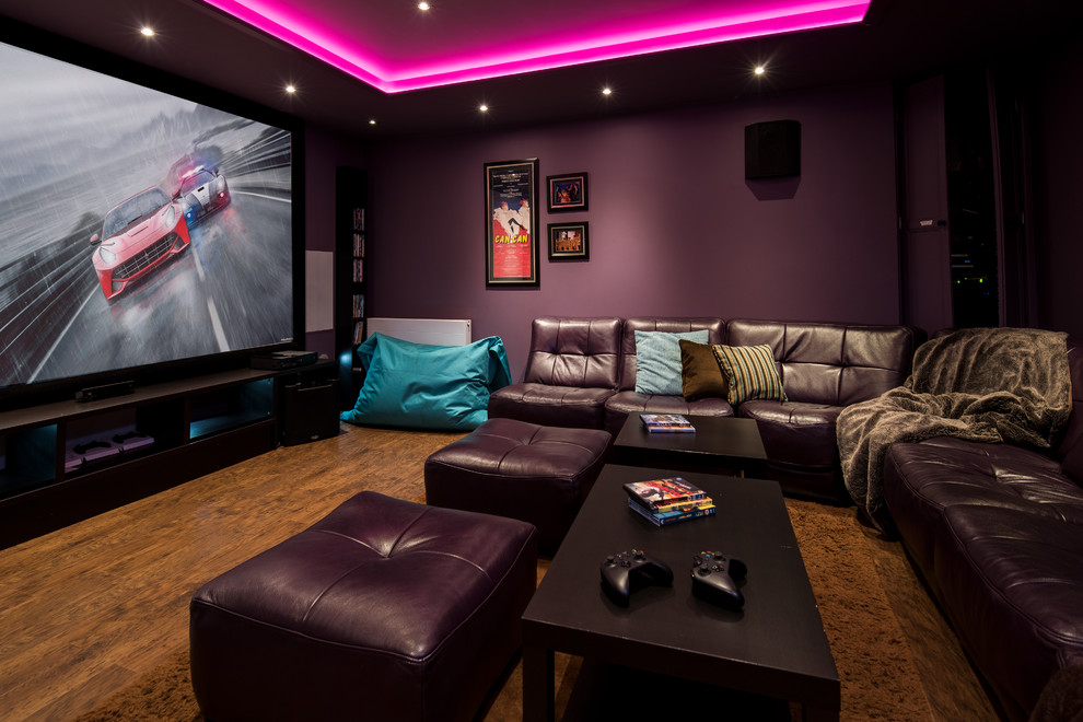 Imagen de cine en casa clásico de tamaño medio con paredes púrpuras, suelo de madera en tonos medios y suelo marrón