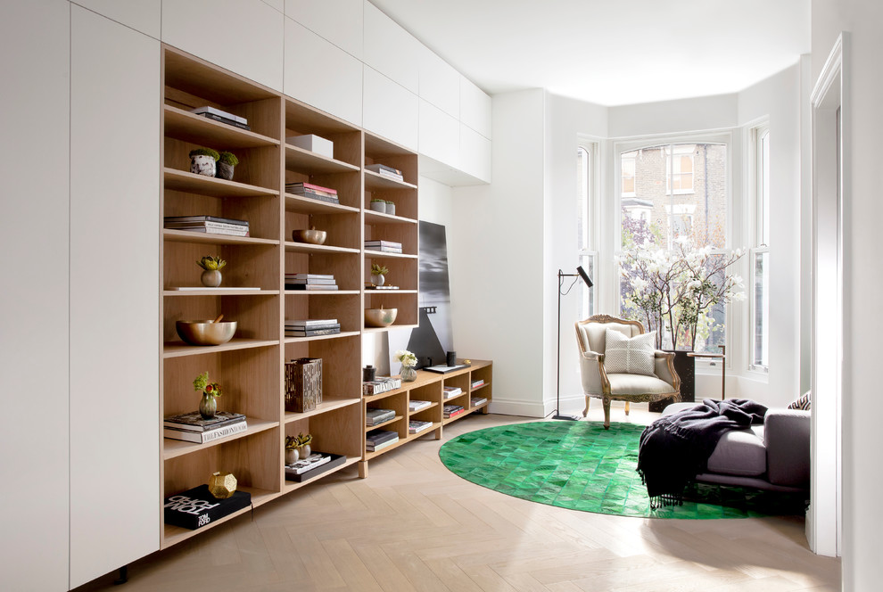 Family room library - mid-sized contemporary open concept light wood floor family room library idea in London with white walls and no tv