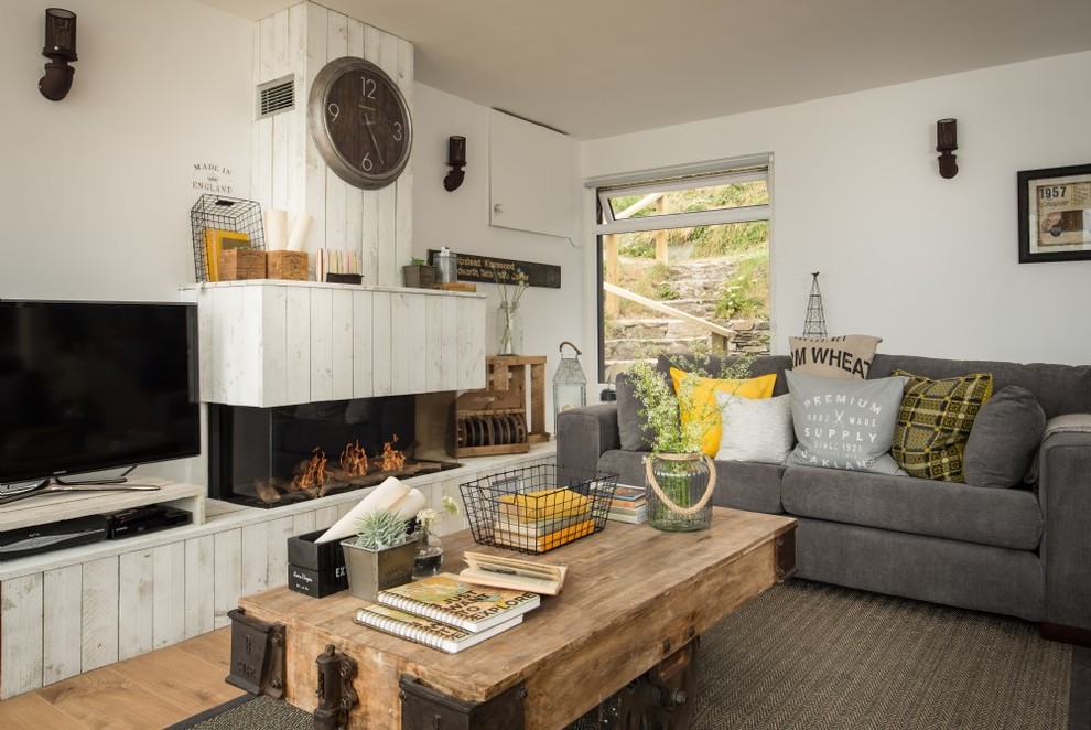 Cette image montre une salle de séjour marine de taille moyenne et ouverte avec un bar de salon, un mur blanc, un sol en bois brun, une cheminée standard, un manteau de cheminée en bois, un téléviseur indépendant et un sol beige.
