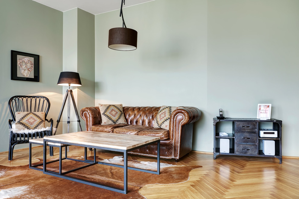 Mittelgroßes, Abgetrenntes Industrial Wohnzimmer ohne Kamin mit grüner Wandfarbe, braunem Holzboden und braunem Boden in Berlin