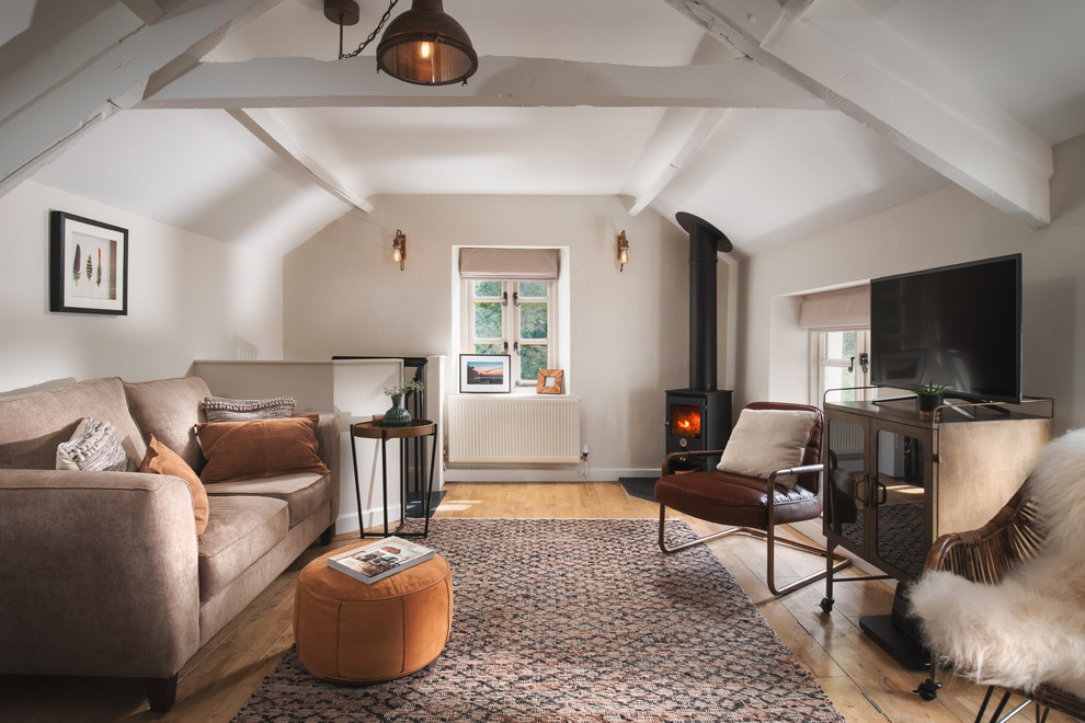 Exemple d'une petite salle de séjour nature ouverte avec un mur beige, un poêle à bois, un sol en bois brun et un sol marron.