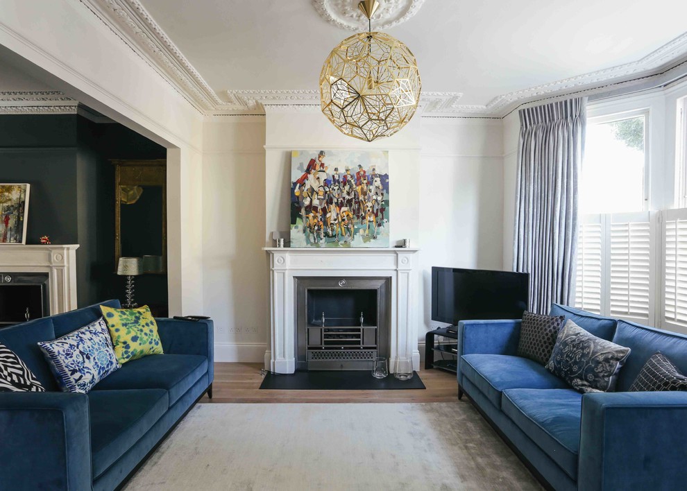 Mittelgroßes Klassisches Wohnzimmer mit weißer Wandfarbe, dunklem Holzboden, freistehendem TV, braunem Boden, Kamin und Kaminumrandung aus Stein in London