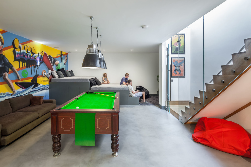 Пример оригинального дизайна: гостиная комната в современном стиле с разноцветными стенами и бетонным полом без камина