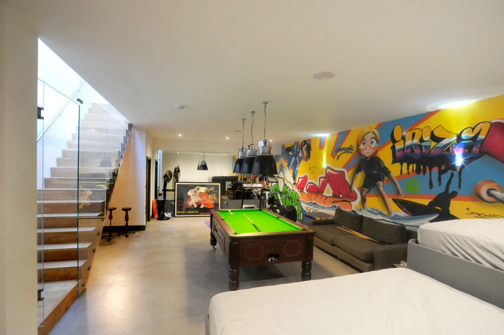 Cette photo montre une salle de séjour tendance avec un mur multicolore, sol en béton ciré et aucune cheminée.