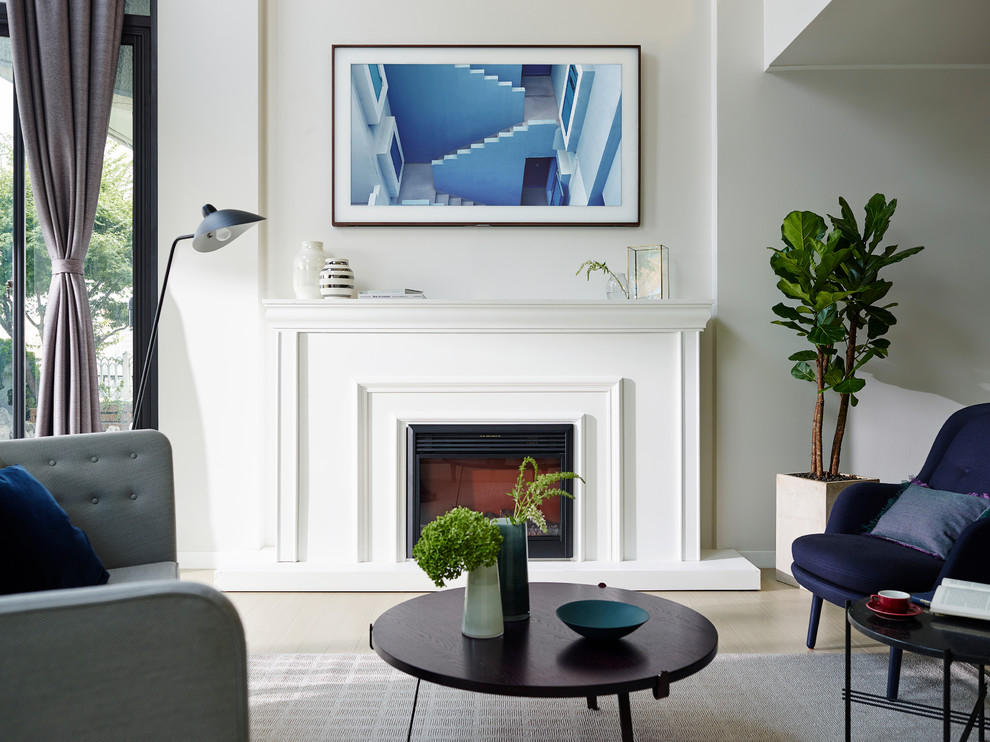 Пример оригинального дизайна: гостиная комната в классическом стиле с стандартным камином и телевизором на стене