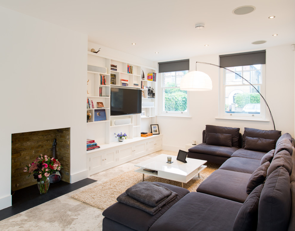 Foto de sala de estar abierta contemporánea pequeña con paredes blancas, suelo de piedra caliza, todas las chimeneas, televisor colgado en la pared y suelo beige