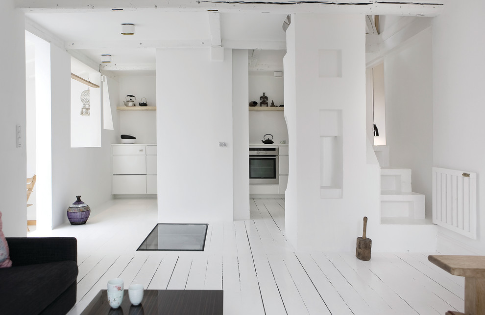 Foto på ett mellanstort skandinaviskt allrum med öppen planlösning, med vita väggar och målat trägolv