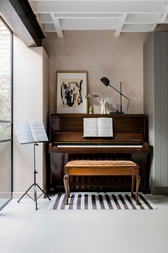 Inspiration for an urban open plan games room in London with a music area, pink walls, concrete flooring and grey floors.