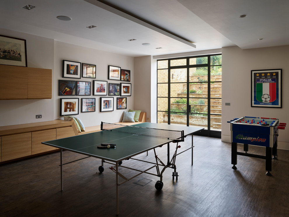 Imagen de sala de juegos en casa cerrada contemporánea de tamaño medio con paredes beige, suelo de madera oscura y suelo marrón