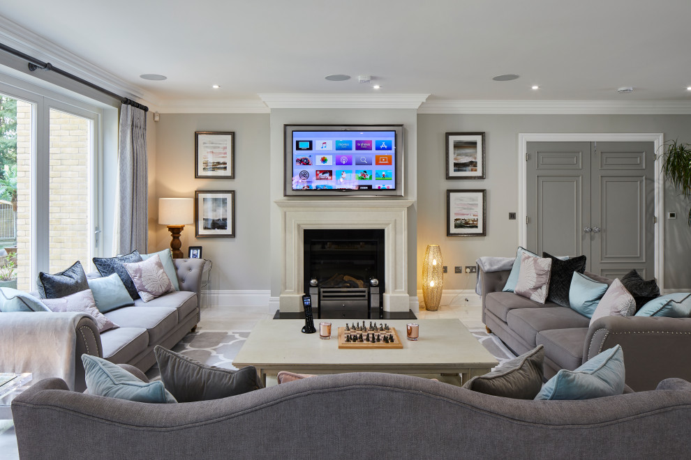 Foto de sala de estar abierta clásica renovada extra grande con suelo de baldosas de porcelana, televisor colgado en la pared, suelo gris, paredes grises y todas las chimeneas