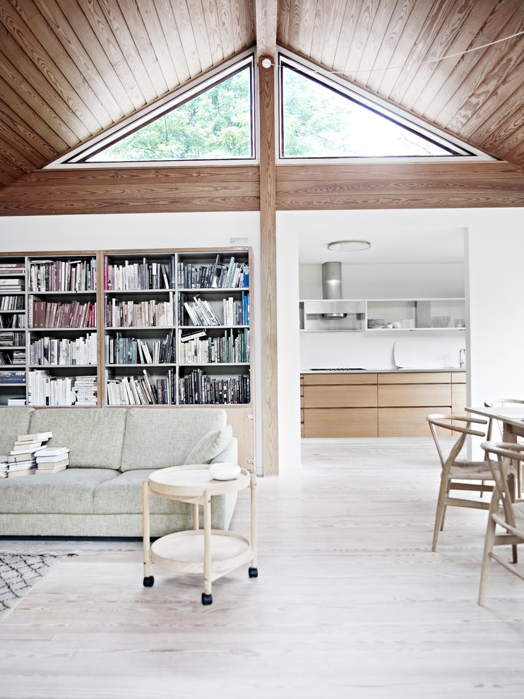 Foto di un grande soggiorno scandinavo con libreria, pareti bianche e parquet chiaro