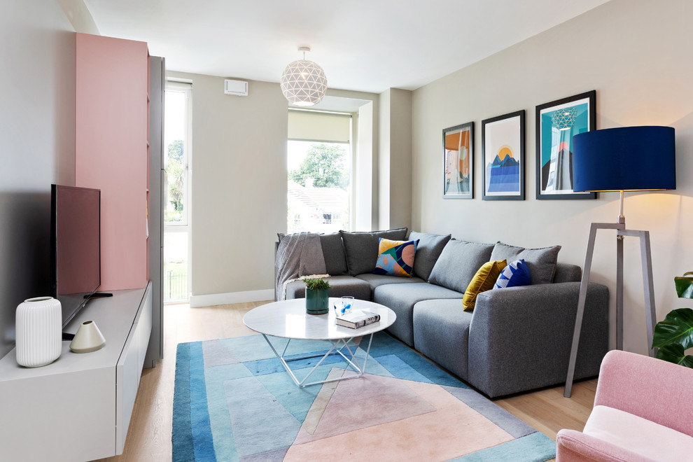 Small danish light wood floor family room photo in Dublin with gray walls, no fireplace and a tv stand