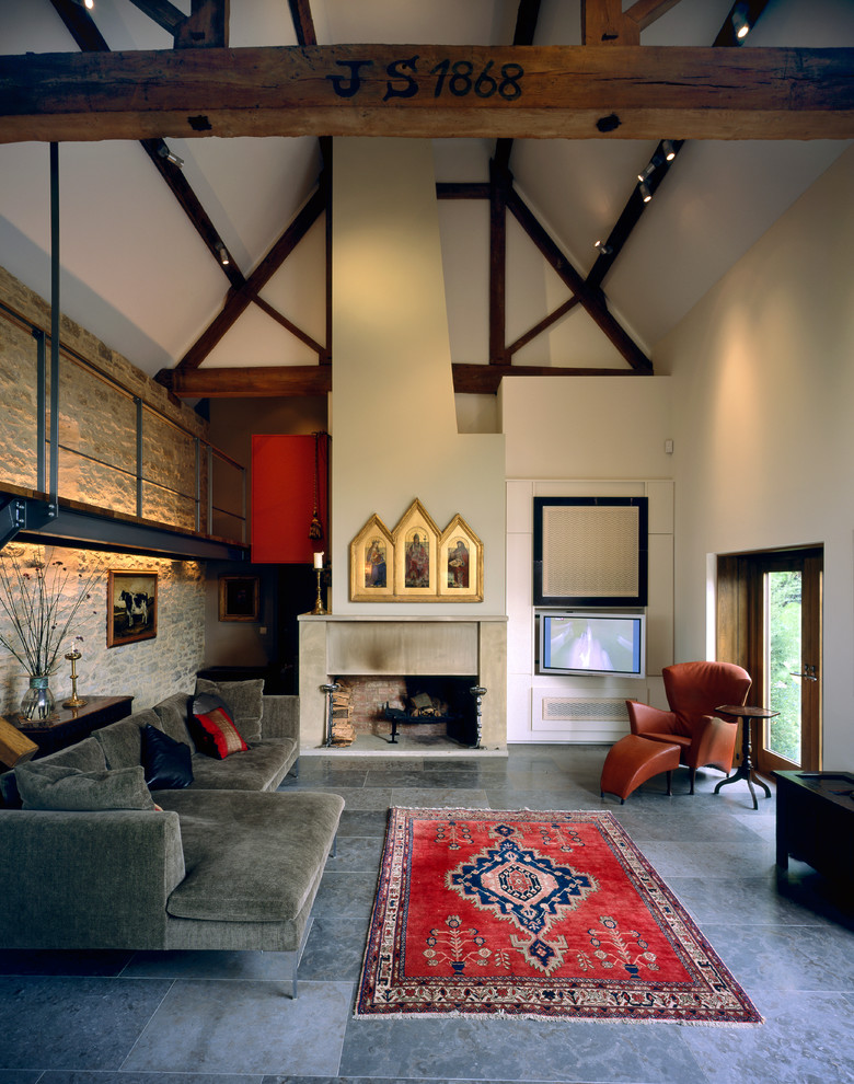 Imagen de sala de estar de estilo de casa de campo grande con todas las chimeneas, marco de chimenea de piedra, suelo gris y paredes blancas