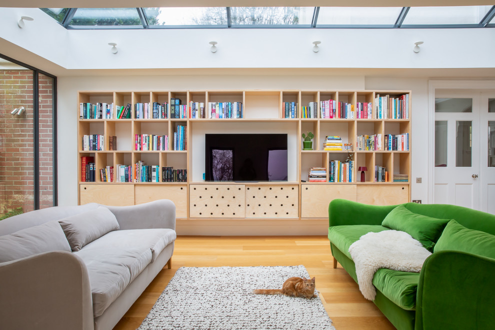 Contemporary games room in Sussex with white walls, medium hardwood flooring, a built-in media unit and brown floors.