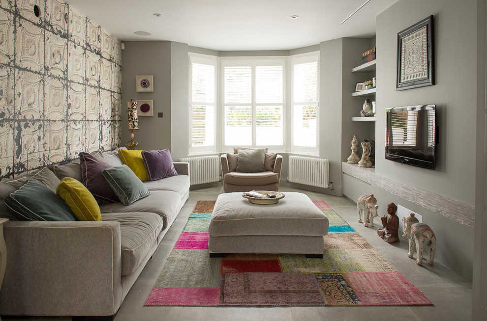 Immagine di un soggiorno bohémian con pareti grigie, TV a parete e pavimento grigio