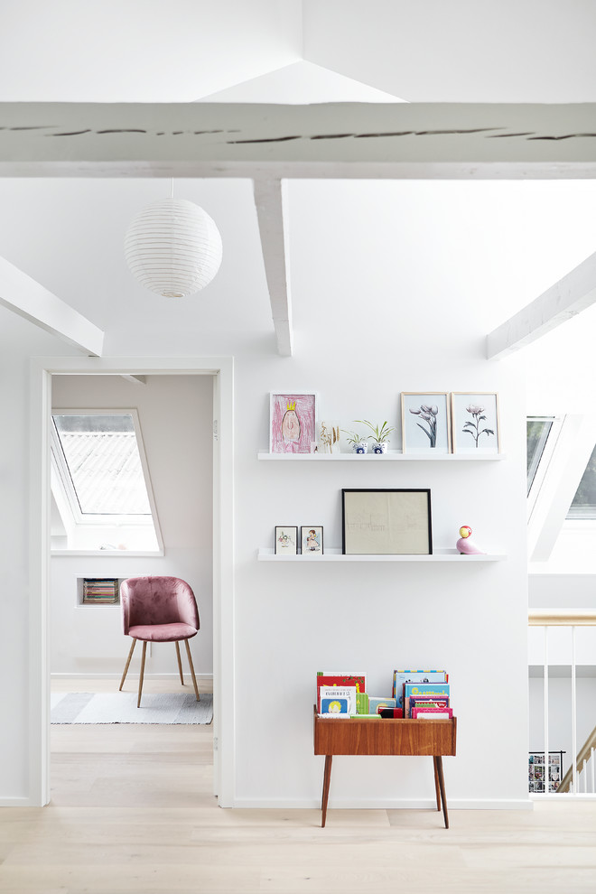 Réalisation d'un couloir nordique avec un mur blanc, parquet clair et un sol beige.