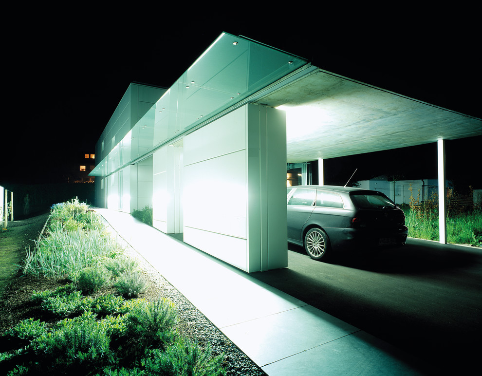 Exempel på en modern tillbyggd enbils garage och förråd, med entrétak