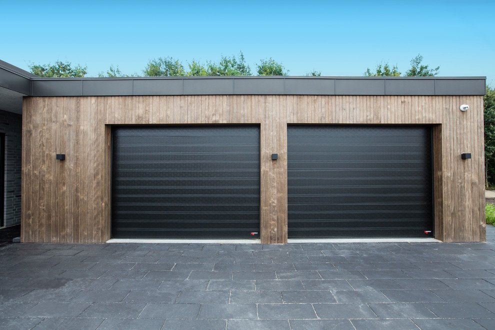 Bild på en mycket stor funkis tillbyggd tvåbils garage och förråd