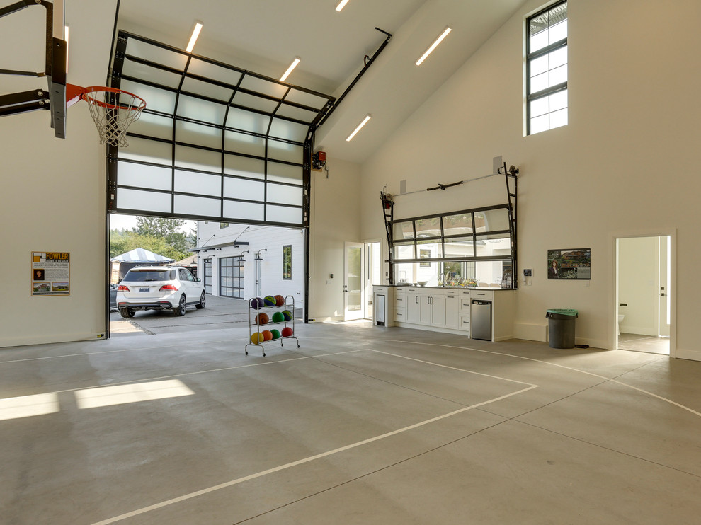 Cette photo montre un très grand garage pour quatre voitures ou plus séparé nature avec un bureau, studio ou atelier.