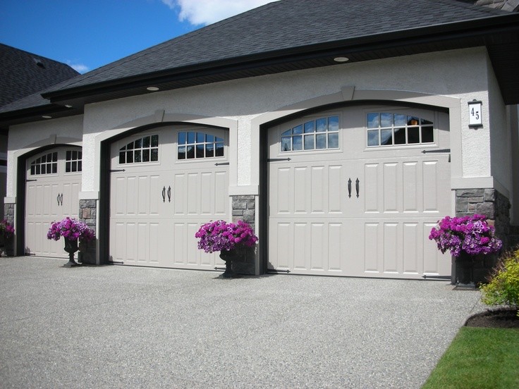 На фото: большой пристроенный гараж в классическом стиле для трех машин