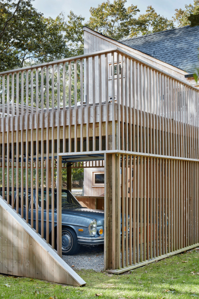 Example of a mid-sized mid-century modern attached two-car carport design in New York