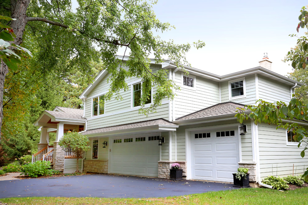 Example of a large arts and crafts attached three-car garage design in Chicago