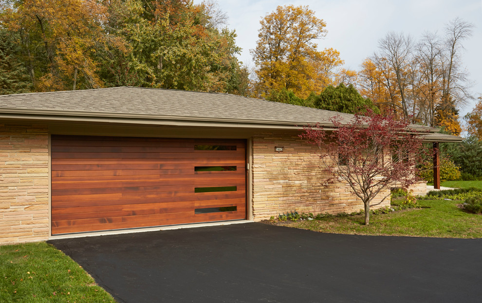 Example of a mid-sized minimalist attached two-car garage design in Milwaukee