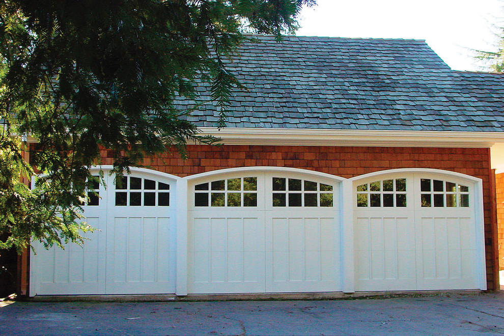 Пример оригинального дизайна: пристроенный гараж среднего размера в классическом стиле для трех машин