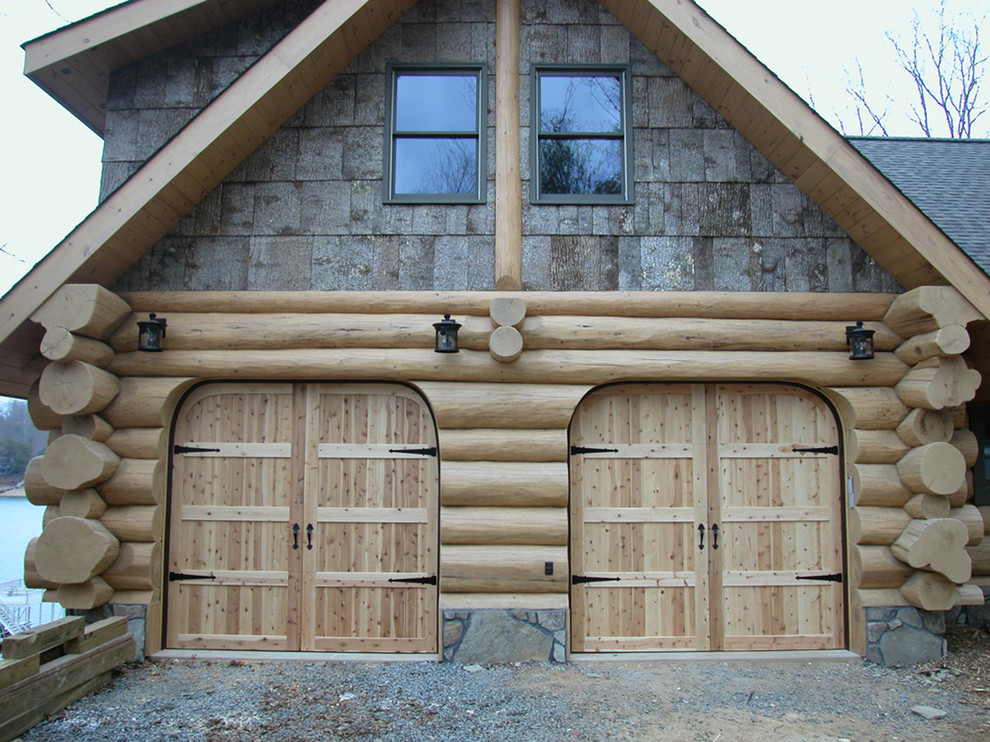 На фото: пристроенный гараж среднего размера в стиле рустика для двух машин