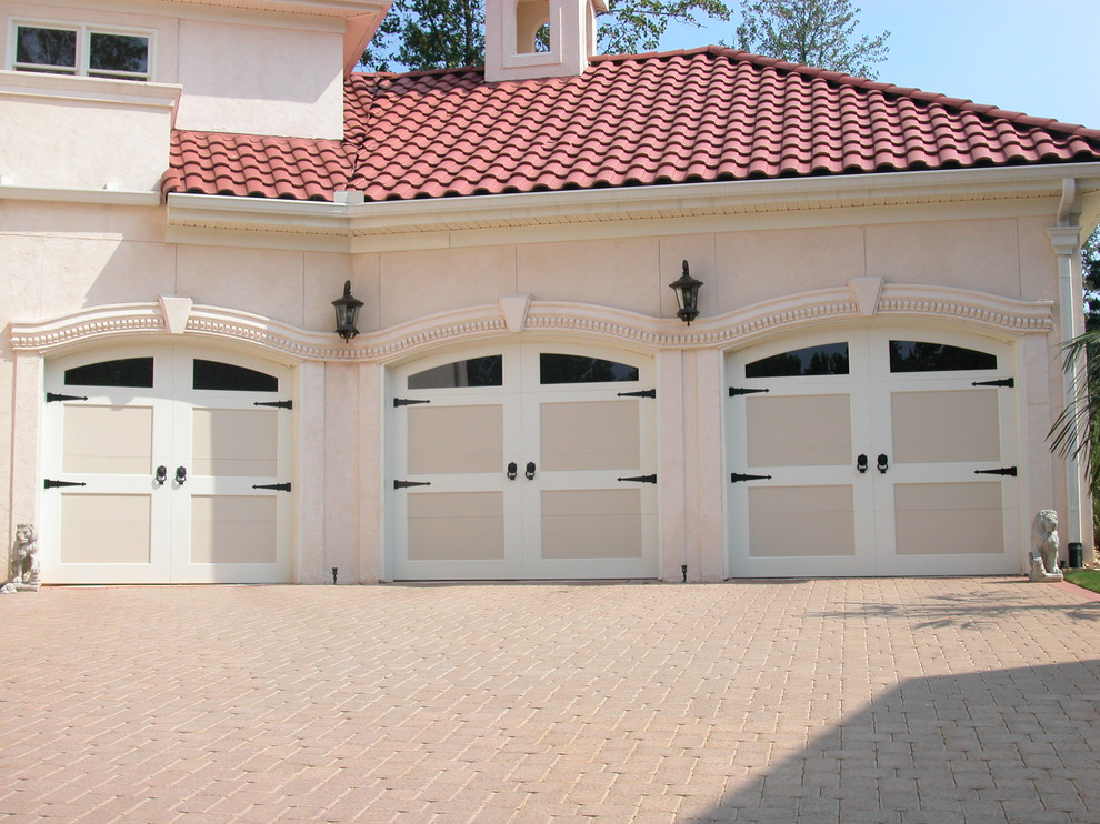 Exemple d'un garage pour trois voitures attenant méditerranéen de taille moyenne.