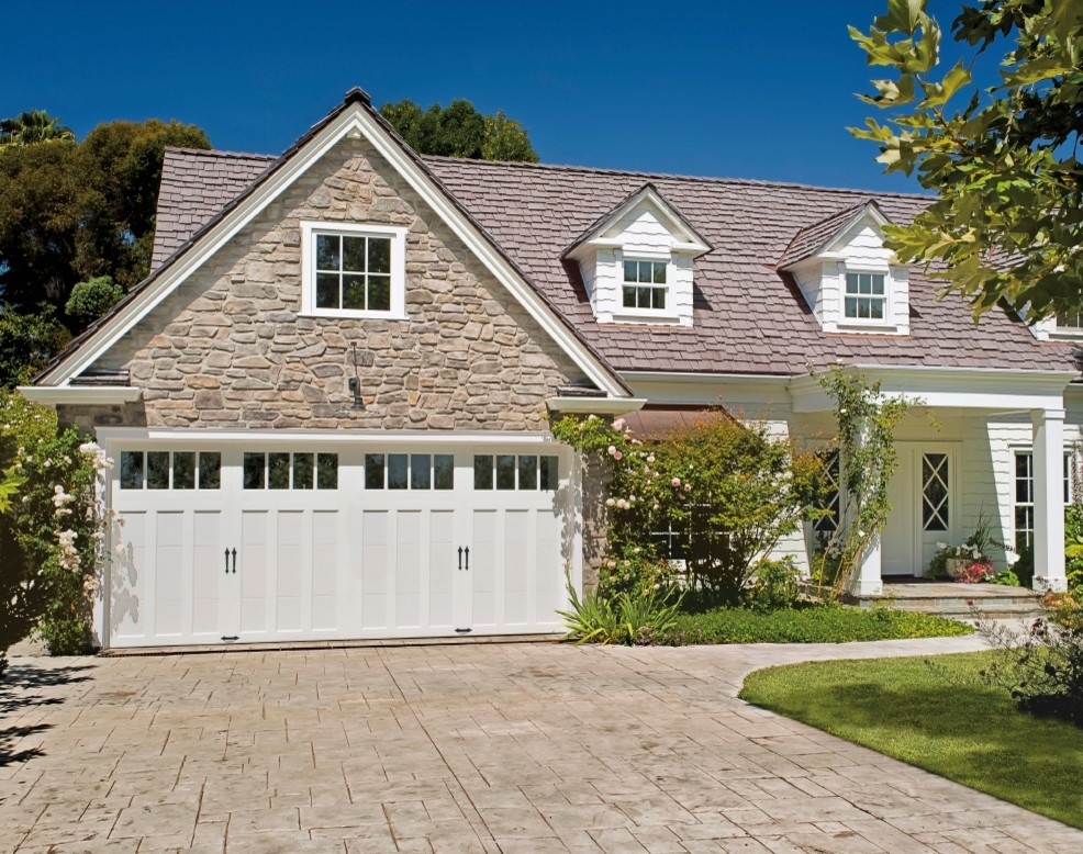 Example of a mid-sized cottage attached two-car garage design in Other