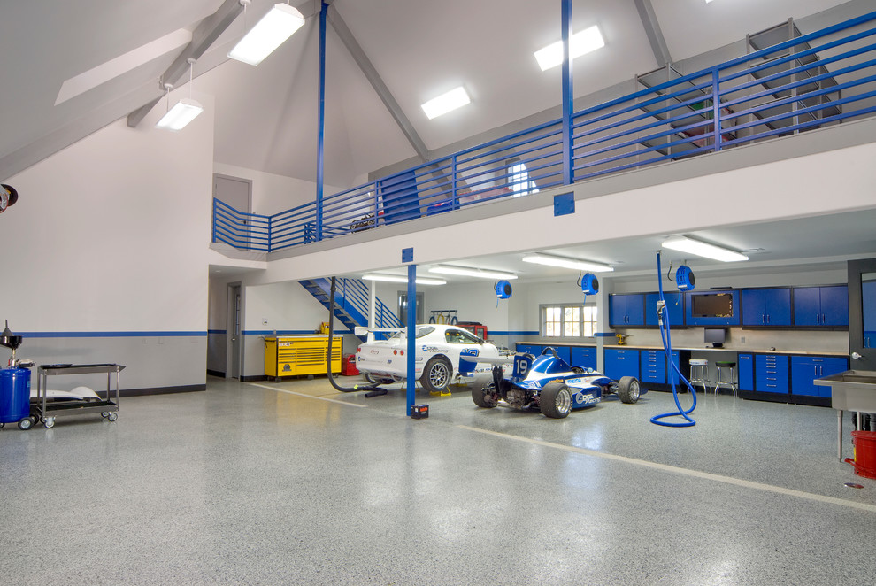 Exemple d'un très grand garage pour trois voitures chic avec un bureau, studio ou atelier.