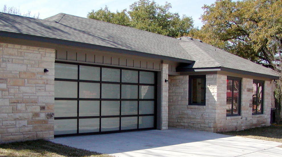 Example of a large minimalist attached two-car garage design in Austin