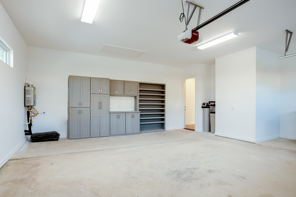 На фото: пристроенный гараж среднего размера в стиле модернизм с мастерской для двух машин