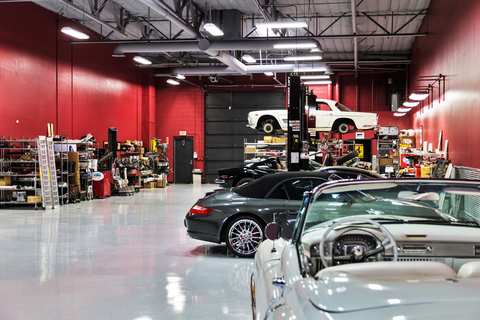 Cette image montre un grand garage pour trois voitures attenant minimaliste avec un bureau, studio ou atelier.
