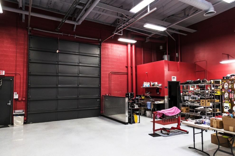 Cette image montre un grand garage pour trois voitures attenant minimaliste avec un bureau, studio ou atelier.