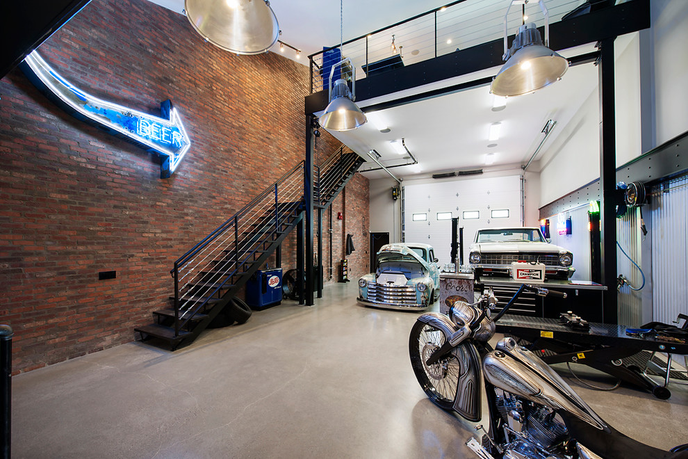 Cette photo montre un très grand garage pour trois voitures industriel avec un bureau, studio ou atelier.