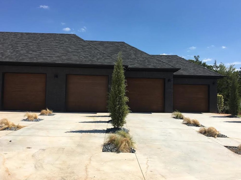 Example of a huge arts and crafts attached four-car garage design in Oklahoma City