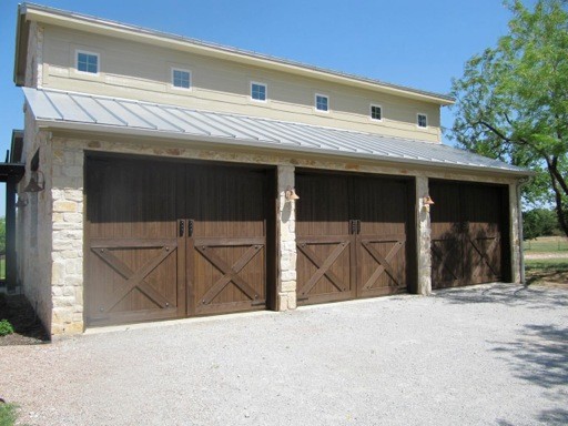 Example of a large classic three-car garage design in Dallas