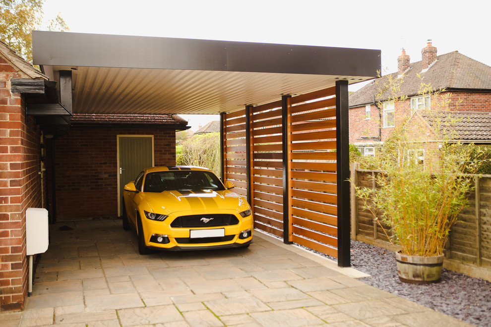 На фото: пристроенный гараж среднего размера в современном стиле с навесом для автомобилей для одной машины с