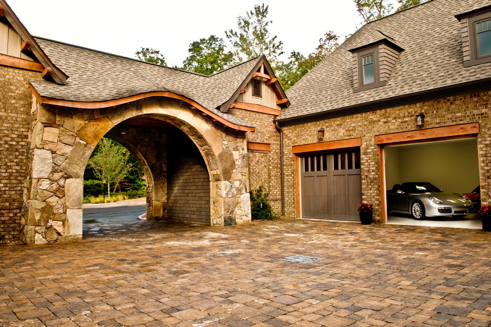 Example of a large arts and crafts attached two-car garage design in Other