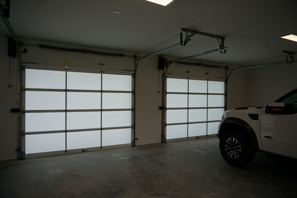 Modern inredning av en stor tillbyggd trebils garage och förråd